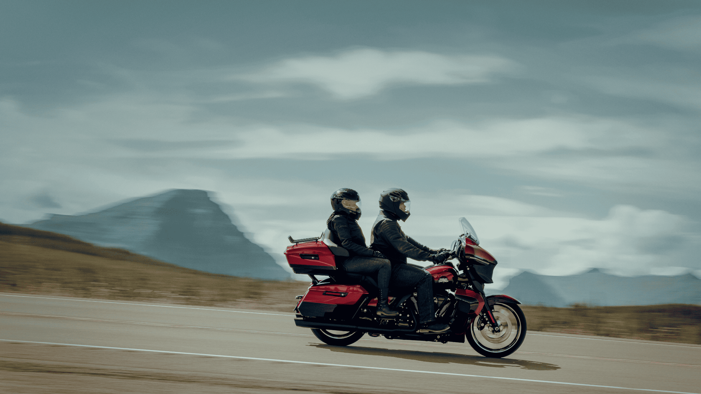 Two riders on a 2025 Harley-Davidson® Street Glide® Ultra cruising down a road near Stafford, TX.
