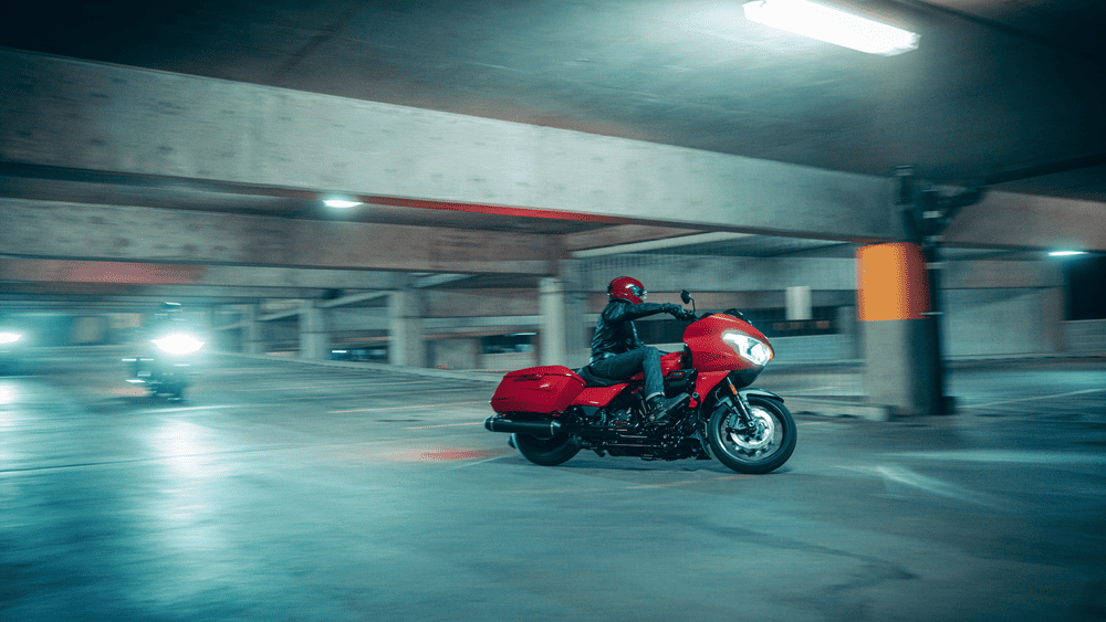 Rider navigating a parking garage on the 2025 Harley-Davidson® CVO™ Road Glide® ST near Missouri City, TX, showcasing its bold red finish and performance stance.