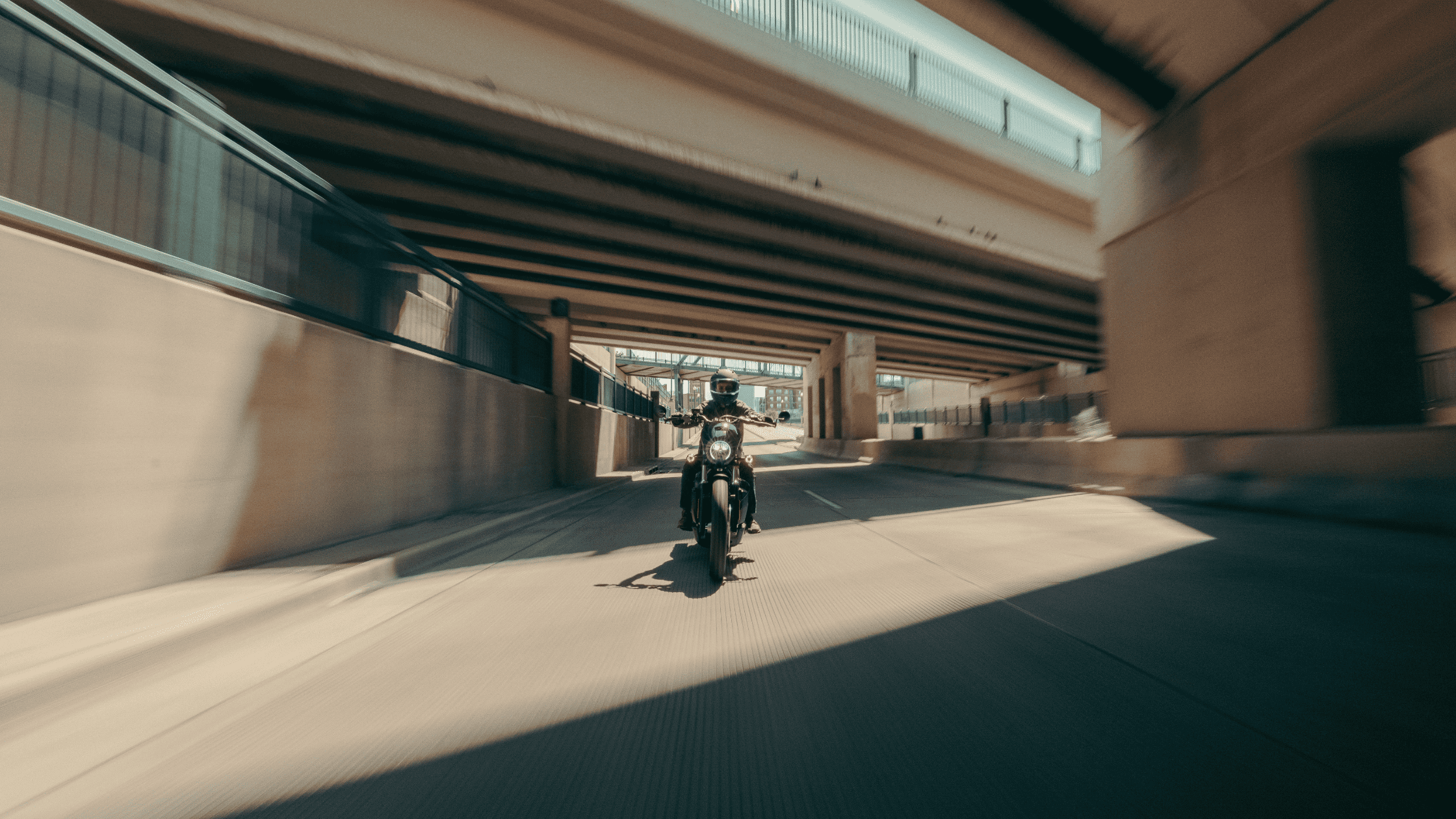 A motorcycle enthusiast cruises on a 2025 Harley-Davidson® Sport Motorcycle, enjoying the thrill of the ride down the street.