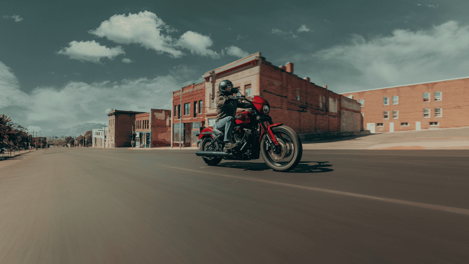 2025 Harley-Davidson® Low Rider® S in red, positioned on a dark studio backdrop to highlight its aggressive stance and performance styling near Missouri City, TX.