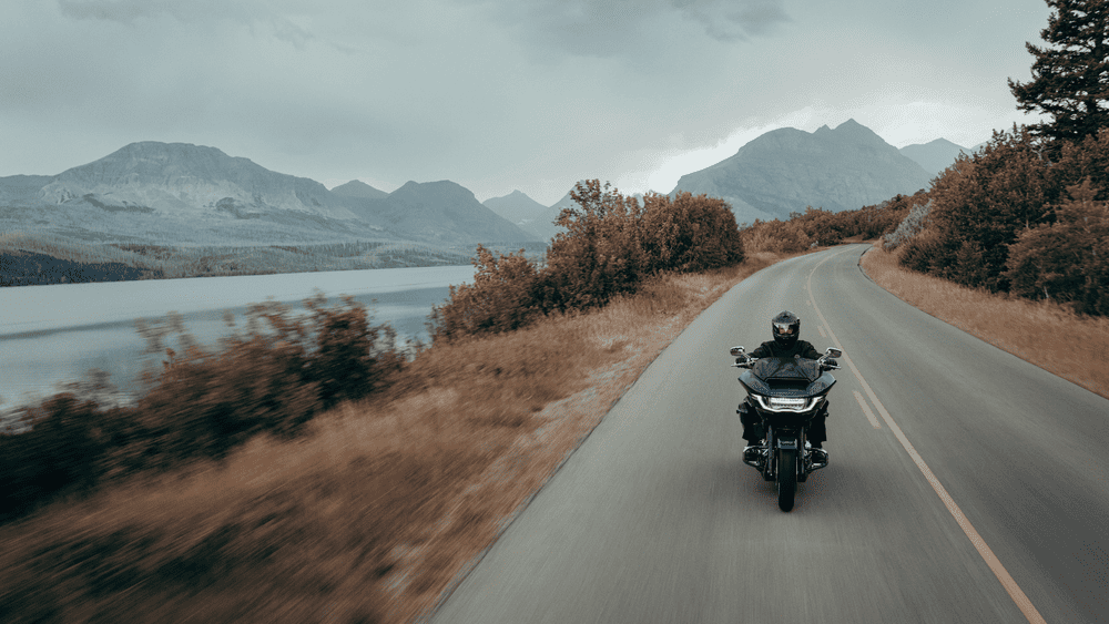 2025 Harley-Davidson® CVO™ Road Glide® riding along a scenic road near Stafford, TX, showcasing its advanced chassis and touring features.