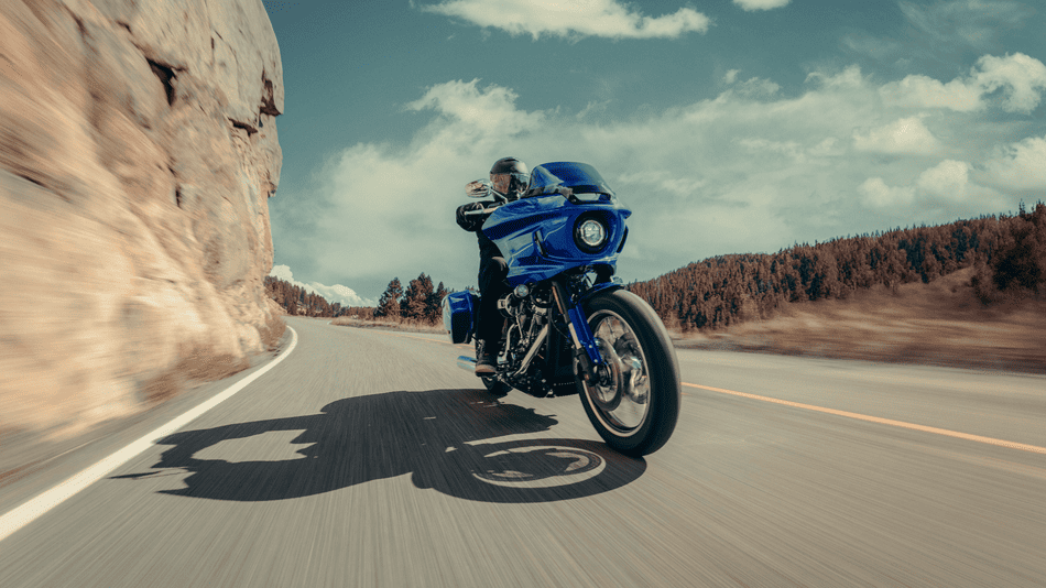 2025 Harley-Davidson® Low Rider® ST in bold blue with saddlebags and touring fairing, captured in a sleek side profile near Missouri City, TX.