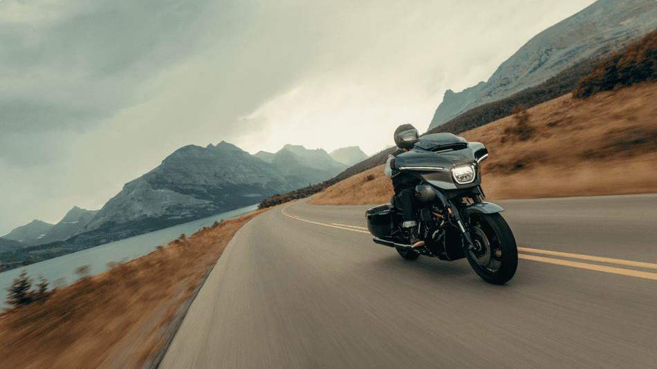 2025 Harley-Davidson® CVO™ Street Glide® glides along a winding mountain road, highlighting its sleek touring design for Texas commuters.