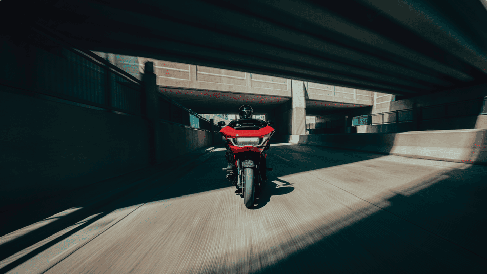 Rider cruises a red 2025 Harley-Davidson® CVO™ Road Glide® ST through a Texas underpass, showcasing its performance-tuned suspension.